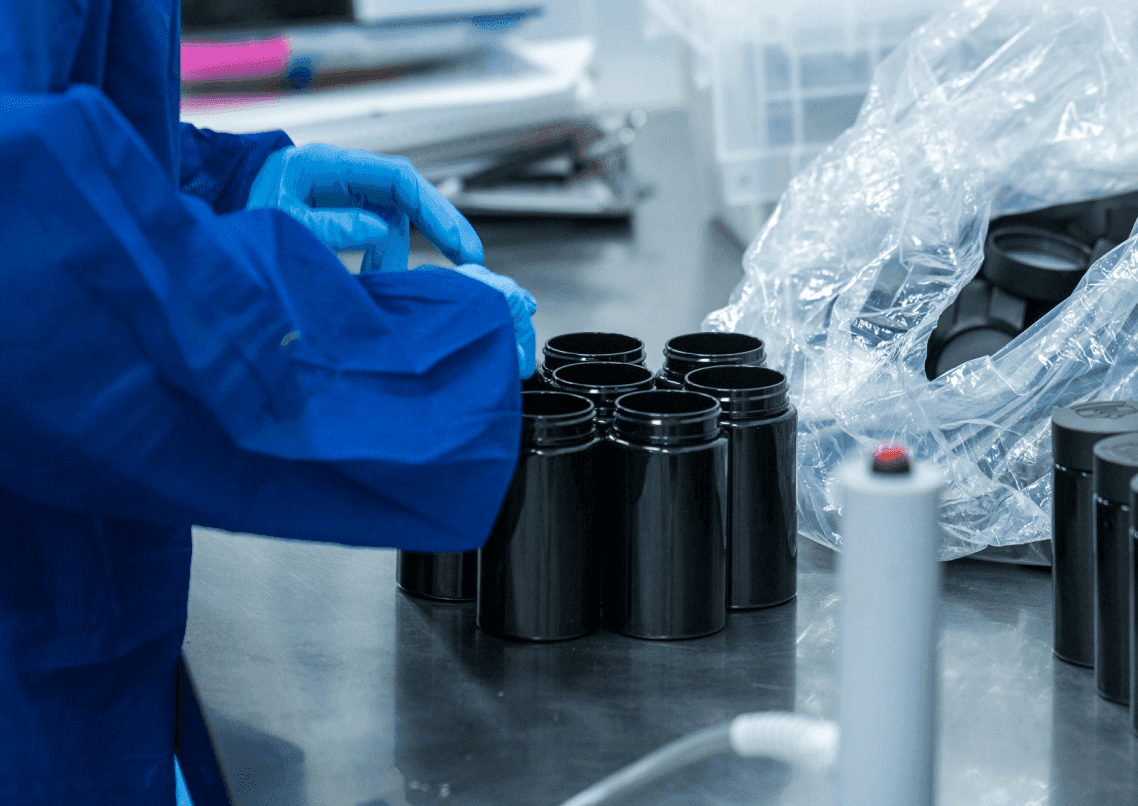 Photograph of cannabis lab worker hands in gloves packaging products